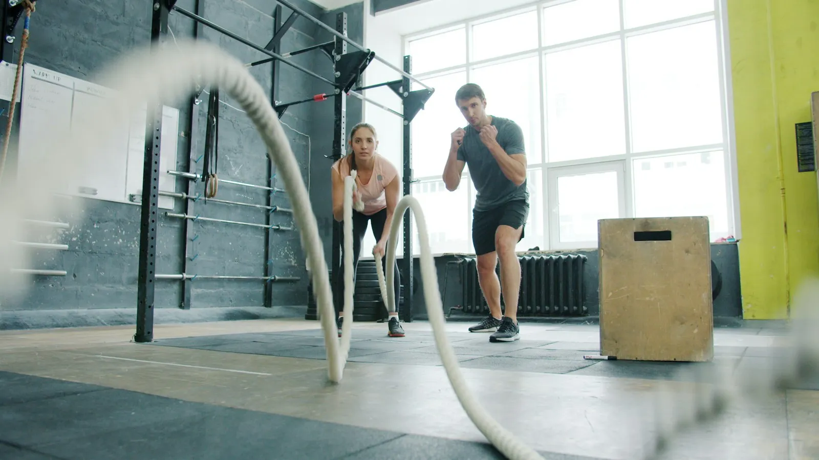 Two athletes training with battle ropes